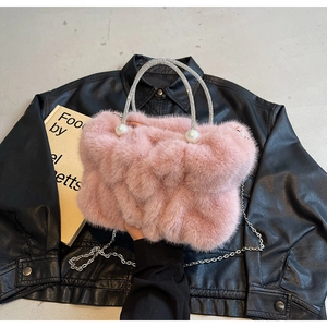 Detail van roze imitatiebont cloud tas met strass handvatten en grote parel details