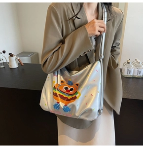 Detail of silver tote bag with cartoon burger print and high-gloss metallic finish
