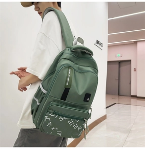 Side view of olive green tactical backpack with racing strap and white geometric print