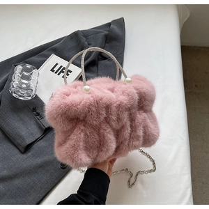 Detail van roze imitatiebont cloud bag met strass handvat en parelmoer accenten