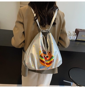 Silver metallic backpack with cartoon cat and Good Luck text shown from a back view