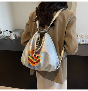 Close-up of a glossy silver backpack with cute cartoon burger and polka dot prints