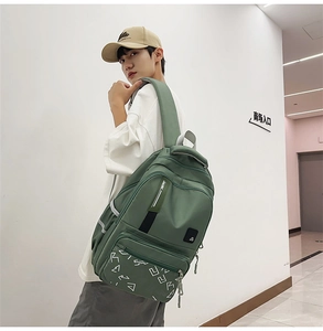 Detailed view of dark green nylon backpack with geometric prints and reflective strips