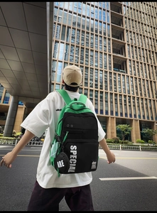 Street view of black and neon green large capacity backpack with bold lettering