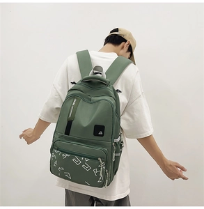 Close-up of the adjustable Racing straps and front pocket detail on the green backpack