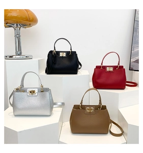 Four chic vintage textured leather handbags in black red silver and brown on white stands