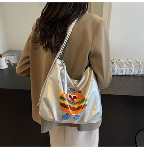 Detail of silver metallic tote bag featuring cartoon burger print and street style text