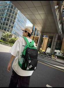 Detail view of fashion backpack with bright green contrast and round charm accessory