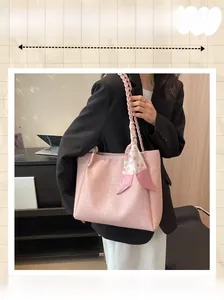 Close-up of pink large tote bag with floral silk scarf and woven shoulder strap detail