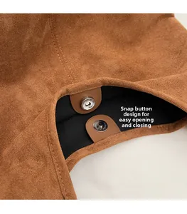 Detail of magnetic snap closure and suede texture on a vintage brown shoulder bag