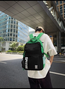 Outdoor shot of green and black fashion backpack featuring large Special letter print