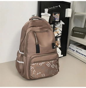 Detail showing reinforced top handle and multi-layer zippers of the taupe backpack