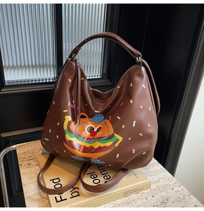 Close-up of a large coffee brown PU leather tote bag with a cute cartoon burger cat print