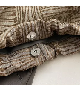 Close-up of the metal magnetic clasp and woven striped texture on a bucket bag