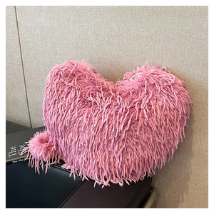 Détail d'un sac à bandoulière rose en fausse fourrure en forme de cœur, texture douce