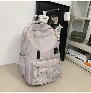 Detail view of water-resistant light grey backpack with multi-layer zipper compartments