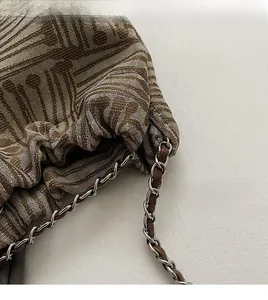 Detail of geometric pattern fabric bag with gold chain and leather shoulder strap