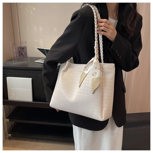 Detail of white embossed tote bag with floral scarf handle and square structure