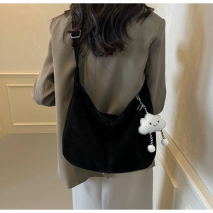 Close-up of black PU shoulder bag with adjustable strap and plush cloud charm