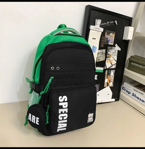 Detail of green and black backpack with mesh pocket and hanging round coin purse