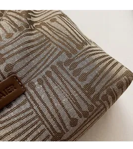Close-up of beige and brown woven fabric texture with brown leather AIER brand logo tag