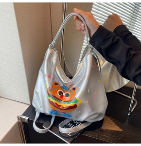 Silver hobo bag with cartoon burger bear and colorful dots print held in hand