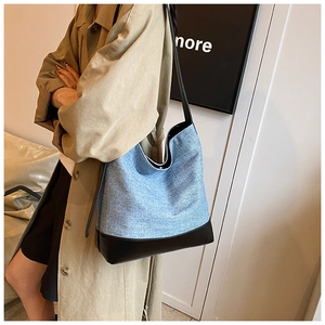Blue denim and black leather bucket bag shown on a model for daily commute style