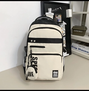 Detail view of large capacity black and white backpack with attached round coin purse