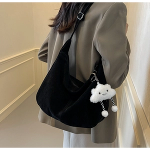 Close-up of black suede large tote bag with a cute white cloud plush pendant detail