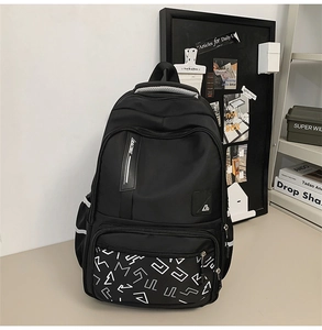 Detail view of large-capacity black backpack showing multi-layer zippers and side pockets