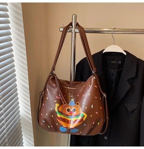 Detail view of coffee leather tote bag featuring a cute cartoon burger bear and sprinkles