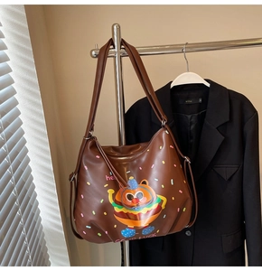 Detail of brown faux leather tote bag featuring a cute cartoon burger print and shoulder straps