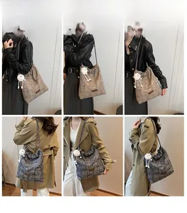 Detail of striped canvas bucket bag with drawstring closure and metal chain strap