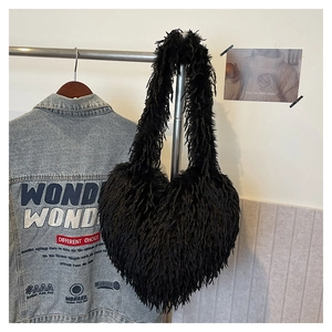 Détail du sac à épaule en fausse fourrure noire en forme de cœur à texture duveteuse