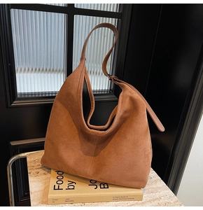 Close-up of a caramel brown suede bucket bag texture on vintage books