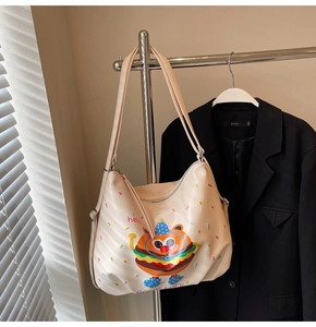 Detail of cute beige tote bag with cartoon burger print and premium leather texture