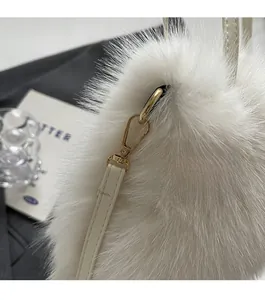 Macro detail of white faux fox fur handbag with premium gold metal hardware and strap