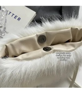 Detail of the white plush faux fur bag featuring a convenient magnetic snap closure