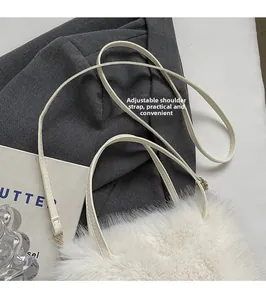Detail of white faux fur crossbody bag featuring an adjustable synthetic leather strap