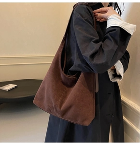 Detail of vintage brown suede tote bag with textured stitching on durable shoulder strap