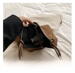 Top view of spacious brown tote bag interior with water bottle and daily essentials