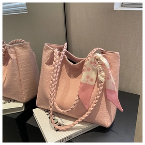 Pink embossed tote bag detail with woven handle and cherry pattern silk scarf accent