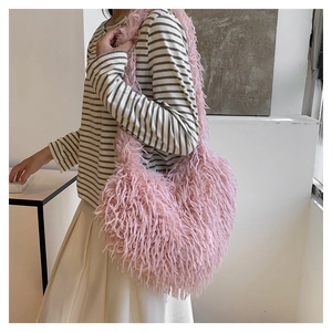 Gros plan d'un sac à bandoulière en fausse fourrure rose porté par un mannequin