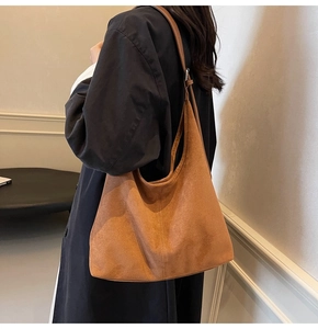 Detail of vintage brown suede hobo bag with adjustable strap shown on model shoulder