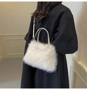 Close-up of plush white faux fur shoulder bag with soft texture and slim top handles