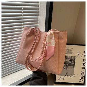 Detail of pink houndstooth tote bag featuring woven handle and cherry print silk scarf accent