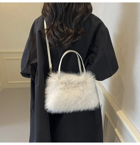Detail of white faux fur crossbody bag shown with a black coat for stylish winter contrast