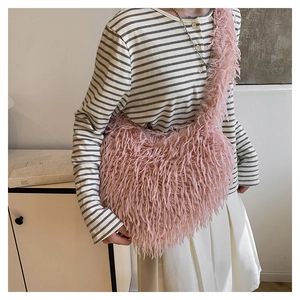 Vue détaillée de la texture en fausse fourrure rose sur un sac à épaule tendance
