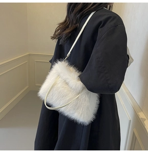Detail of white faux fur shoulder bag with leather strap and silver metal hardware