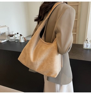 Detail of soft camel suede tote bag with reinforced stitching and premium matte texture